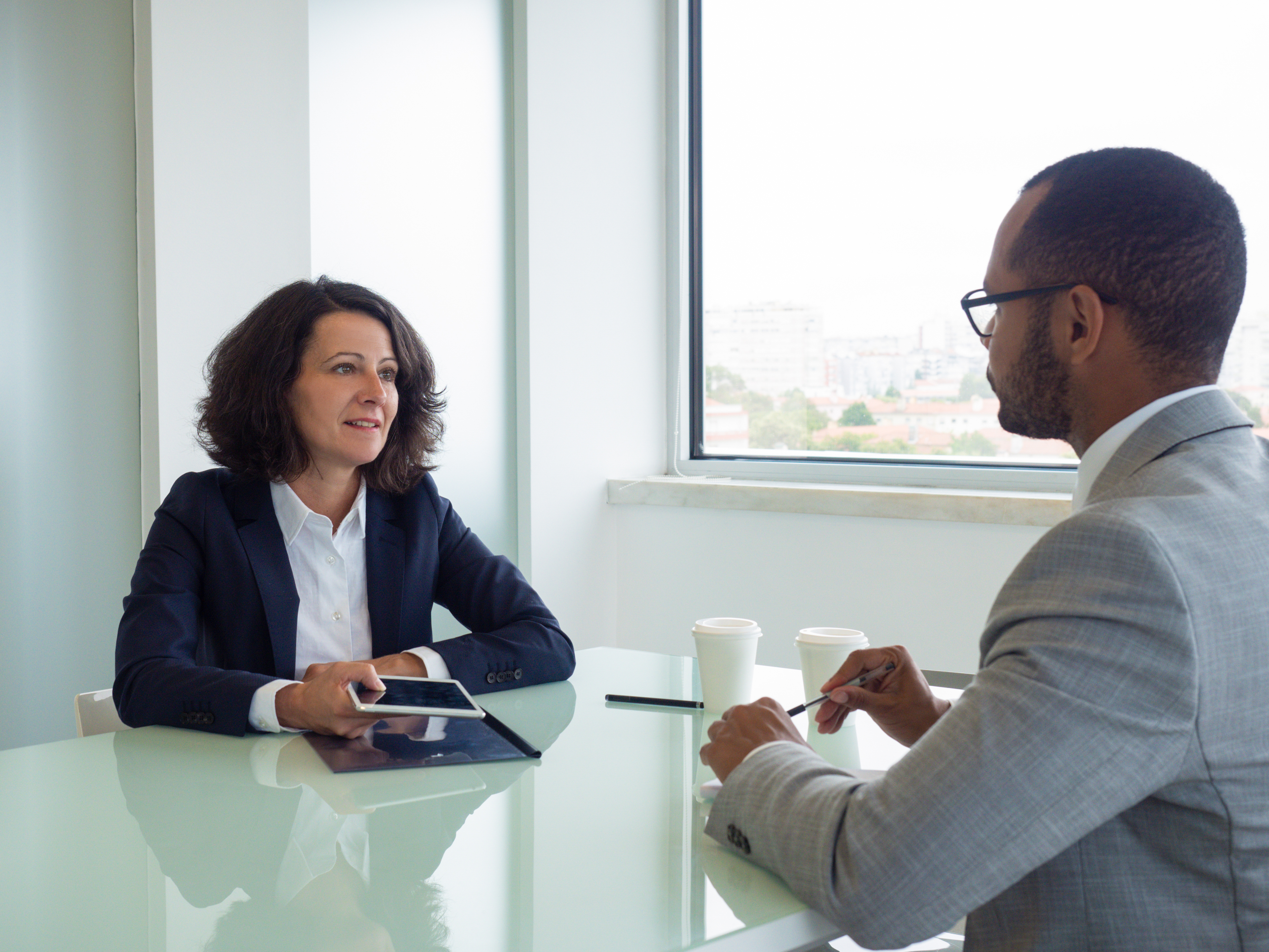 A lawyer meeting two clients across a conference table during a case review.